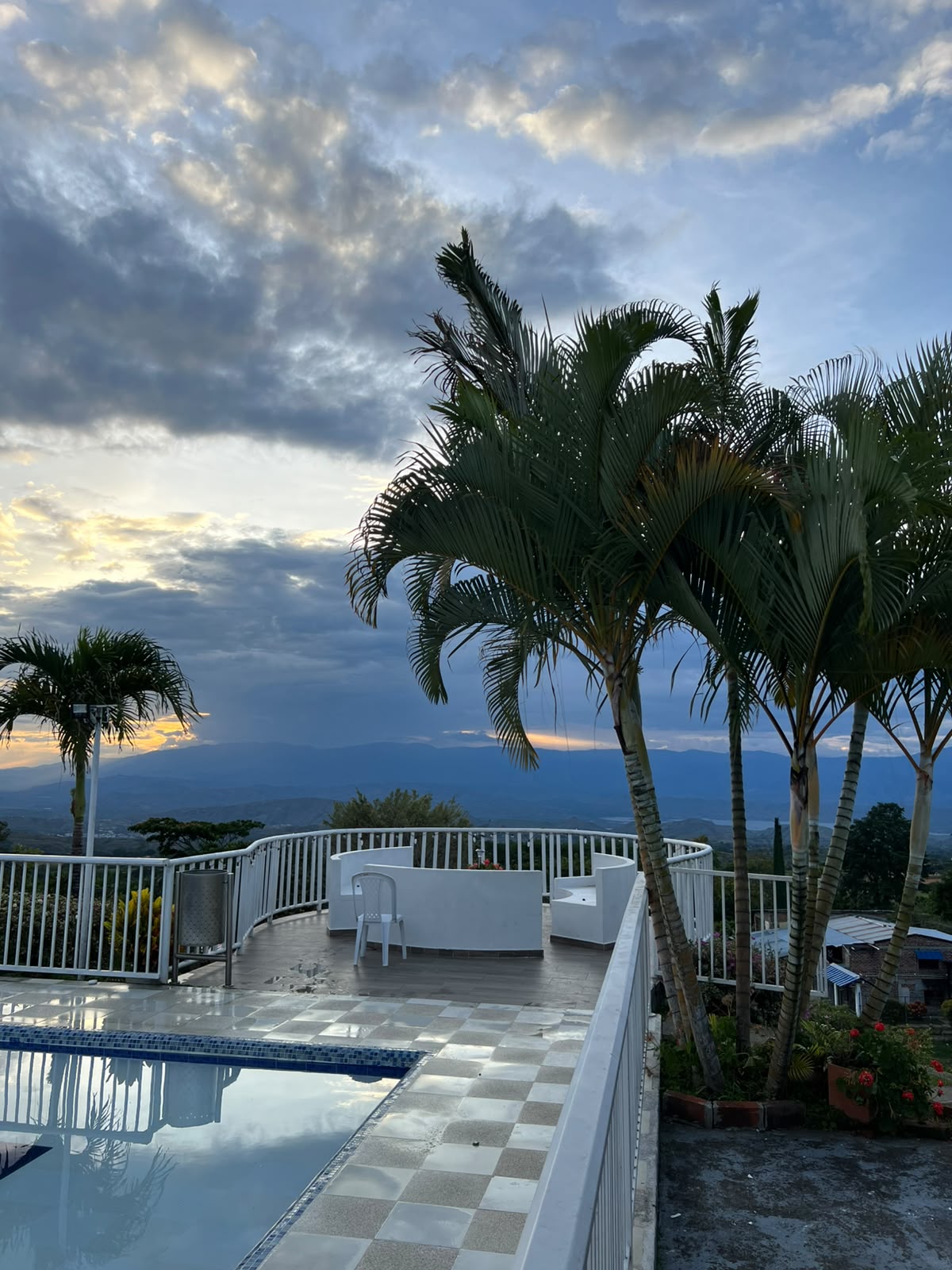 Terraza al atardecer junto a la piscina con palmeras