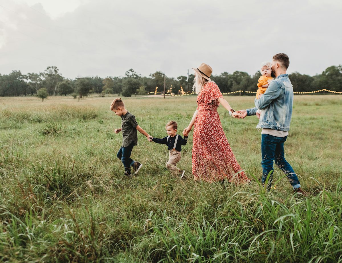 Familia caminando junta por un campo verde